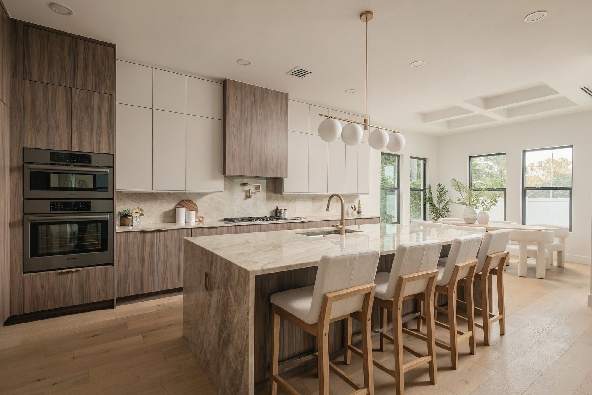 Open kitchen with tall wood cabinets and a stone island