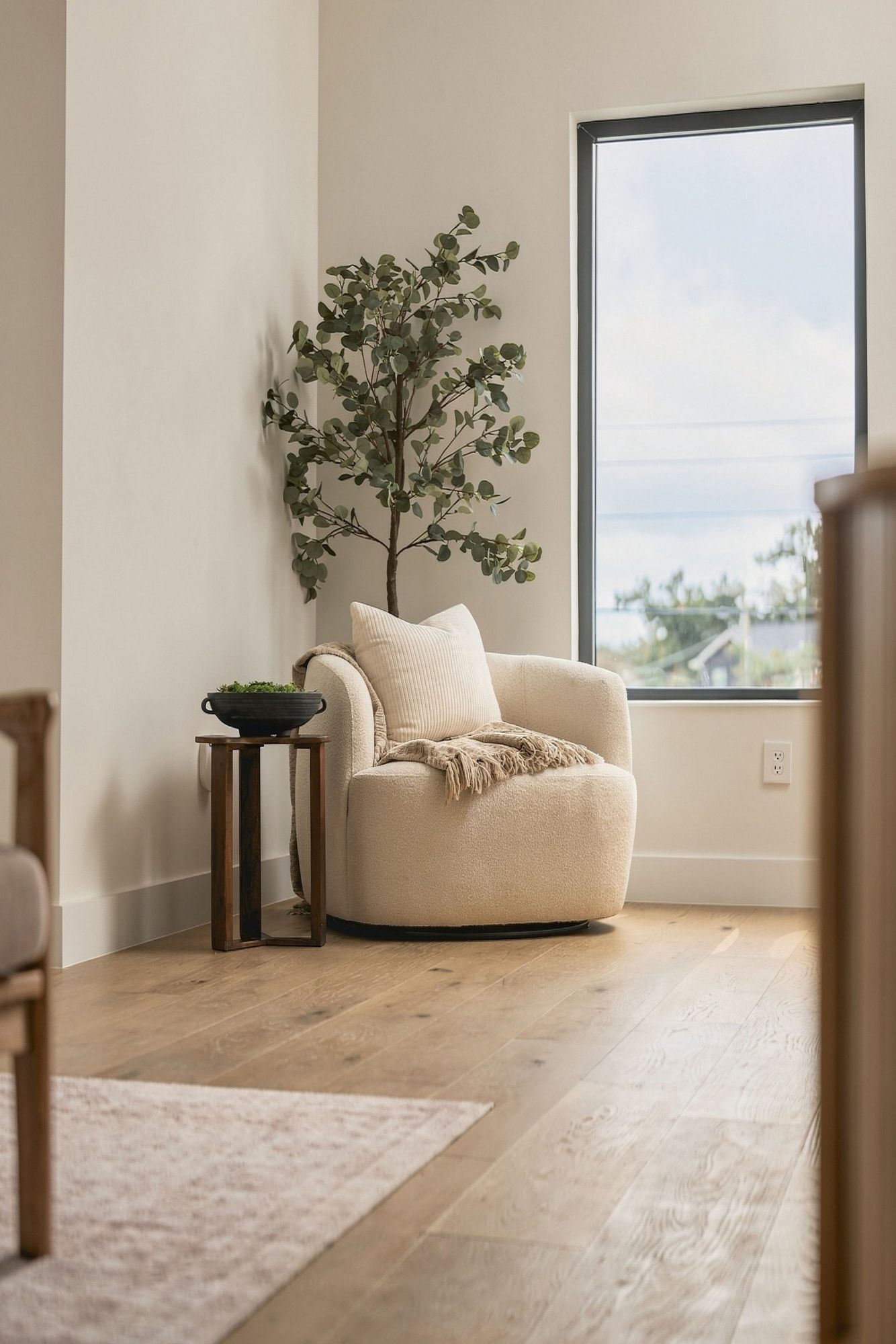 Reading corner with a boucle chair beside a tall window